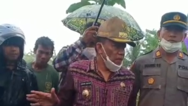 Bupati Malaka, Dr.Simon Nahak, SH.MH, didampingi aparat kepolisian Polres Malaka sedang memantau dampak banjir di Desa Naimana, Kecamatan Malaka Tengah.