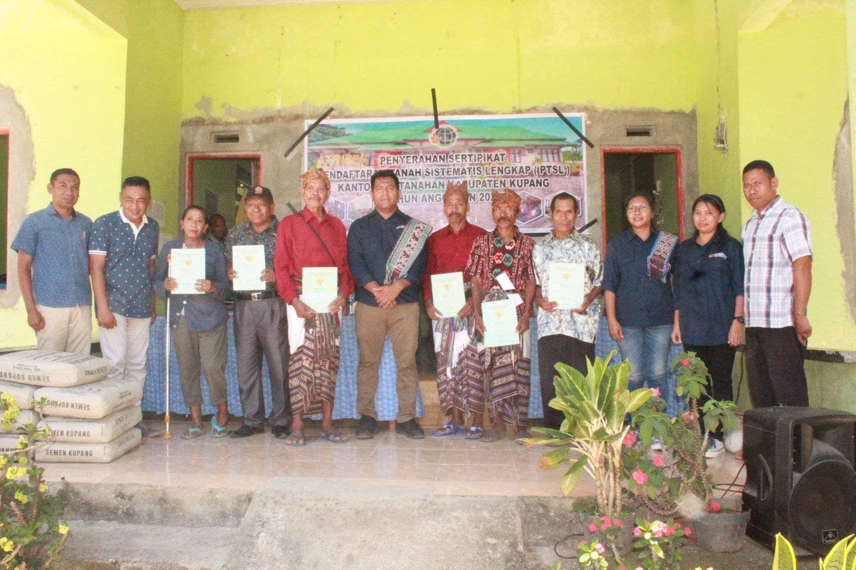Kepala Desa Oeletsala, In Bilaut (pertama/kiri) dan Kasi Survei dan Pengukuran Kantor Pertanahan Kabupaten Kupang (tengah/berselendang) pose bersama masyarakat penerima sertifikat di Desa Oeletsala. Foto : istimewa. 