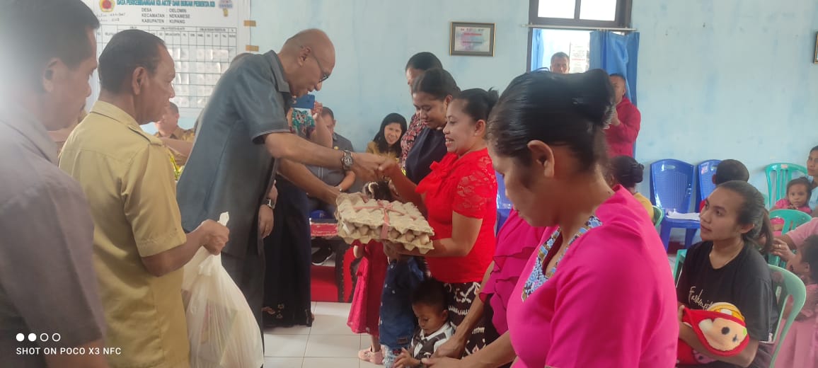 Staf Ahli Bupati Kupang, Marten Rahakbaw, sedang menyerahkan telur kepada anak-anak stunting. Foto : Prokopim Kab.Kupang. 
