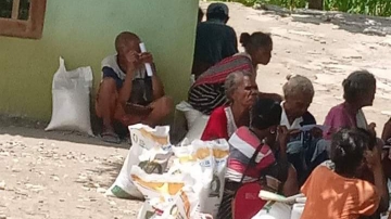 Warga Desa Alala sedang mengantri untuk menerima beras rawan pangan yang dibagikan Dinas Ketahanan Pangan Kabupaten Malaka. Foto: istimewa. 